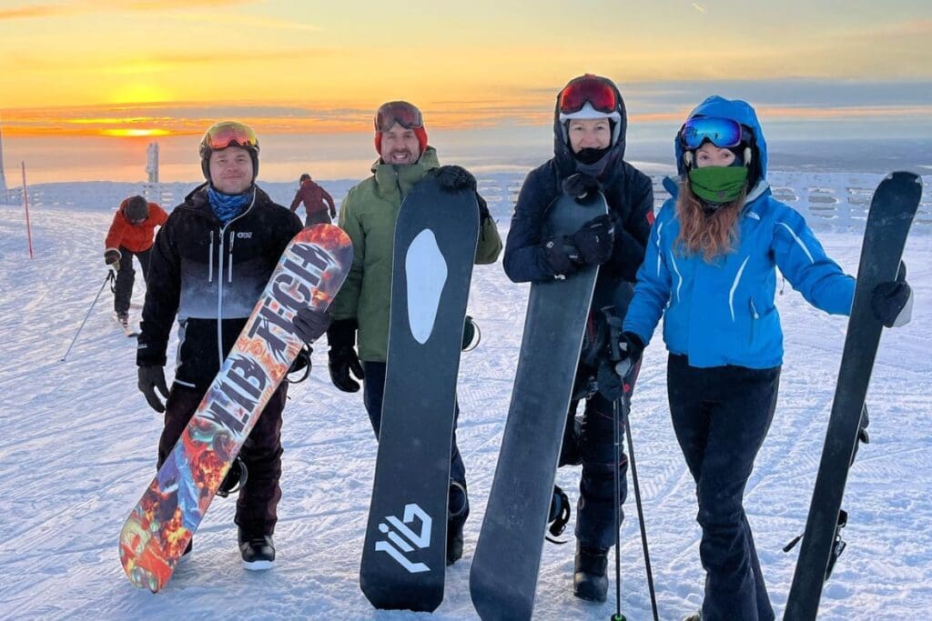 Finland yoga retreat guests snowboarding in the wilderness