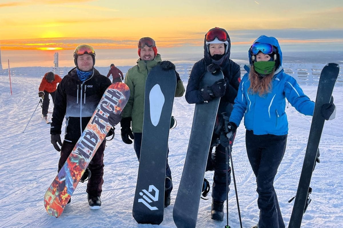 Finland yoga retreat guests snowboarding in the wilderness