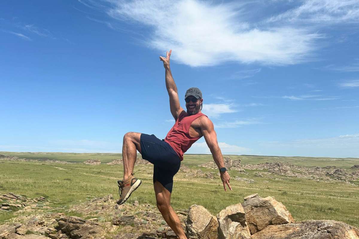 yoga teacher james raffael posing on a rock in the gob desert in mongolia