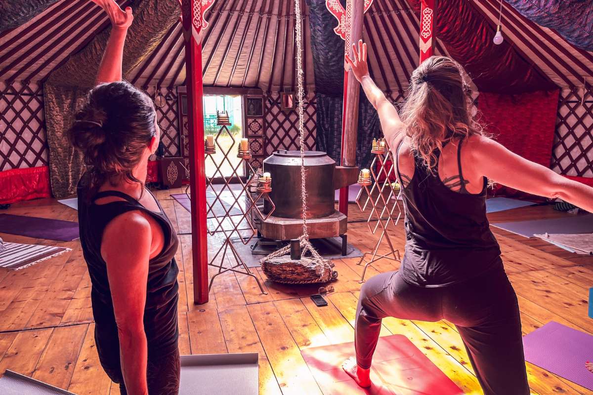 guests practicing yoga in an ornately decorated ger in the wilderness of mongolia