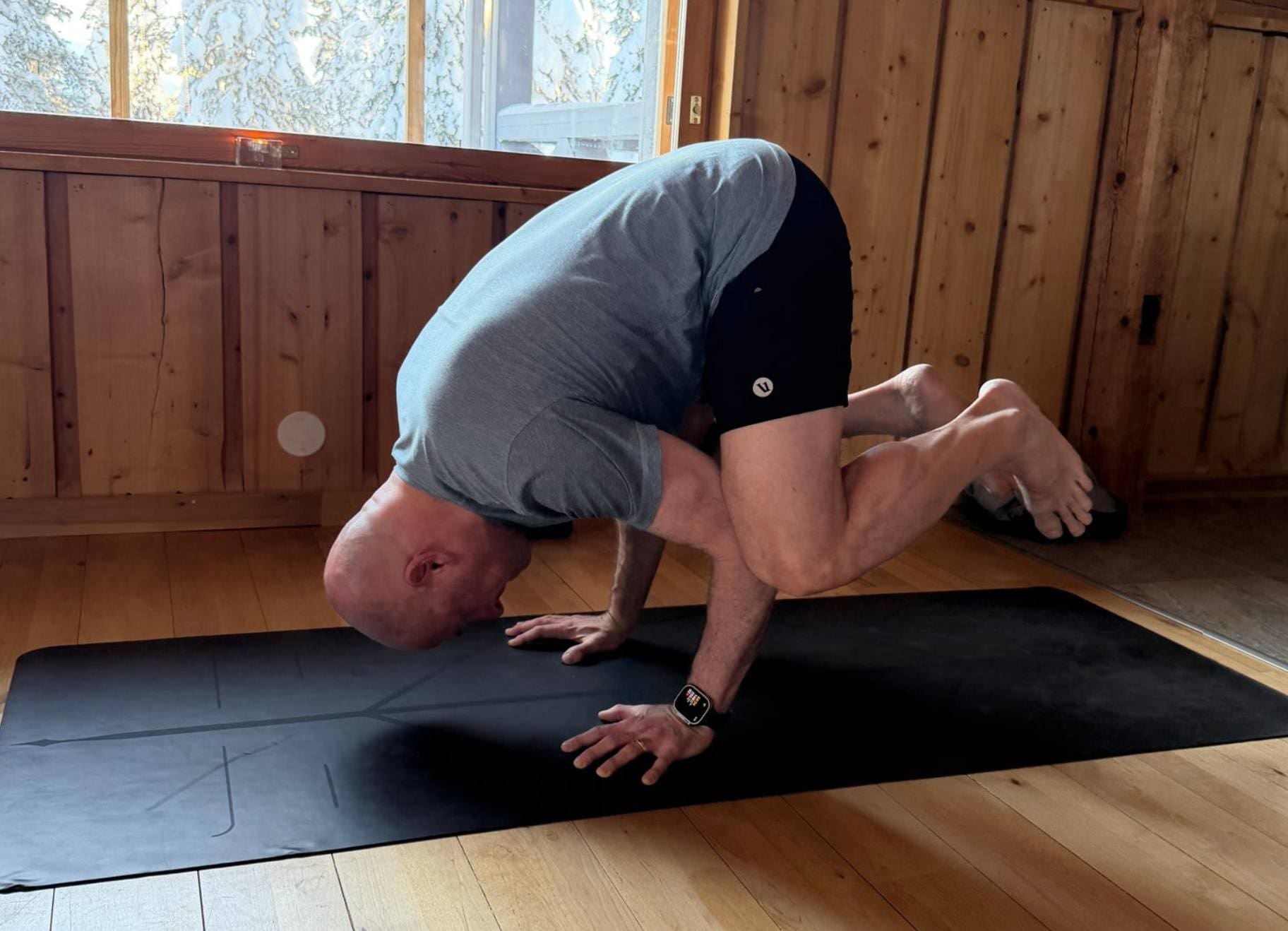 male guest learning a new yoga pose on retreat in finland
